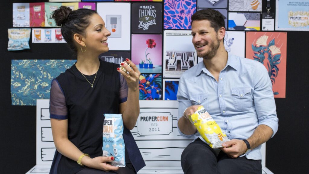 The founders of snack company PROPER Cassandra Stavrou and Ryan Kohn with popcorn